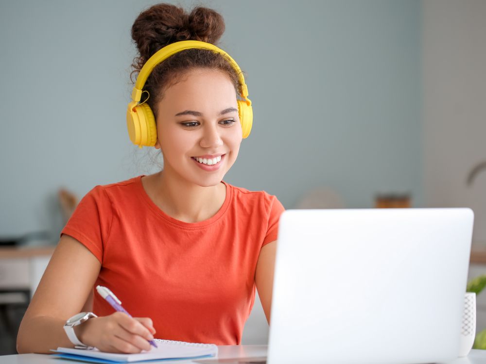 Jovem estudando a distância com notebook, ilustra as exigências de interação previstas no novo marco regulatório do EaD para cursos online.