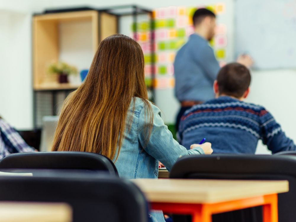 Sala de aula com estudantes durante aula presencial em contexto de acompanhamento acadêmico contínuo.