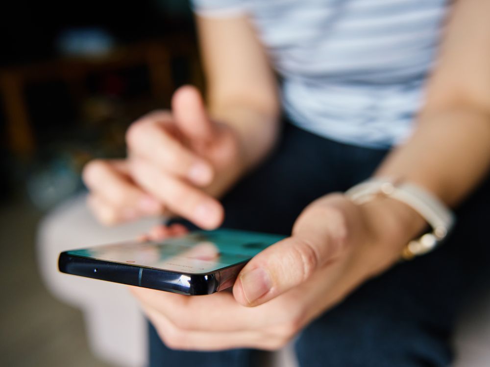 Usuário acessando aplicativo escolar em smartphone com foco em interação e mobilidade digital