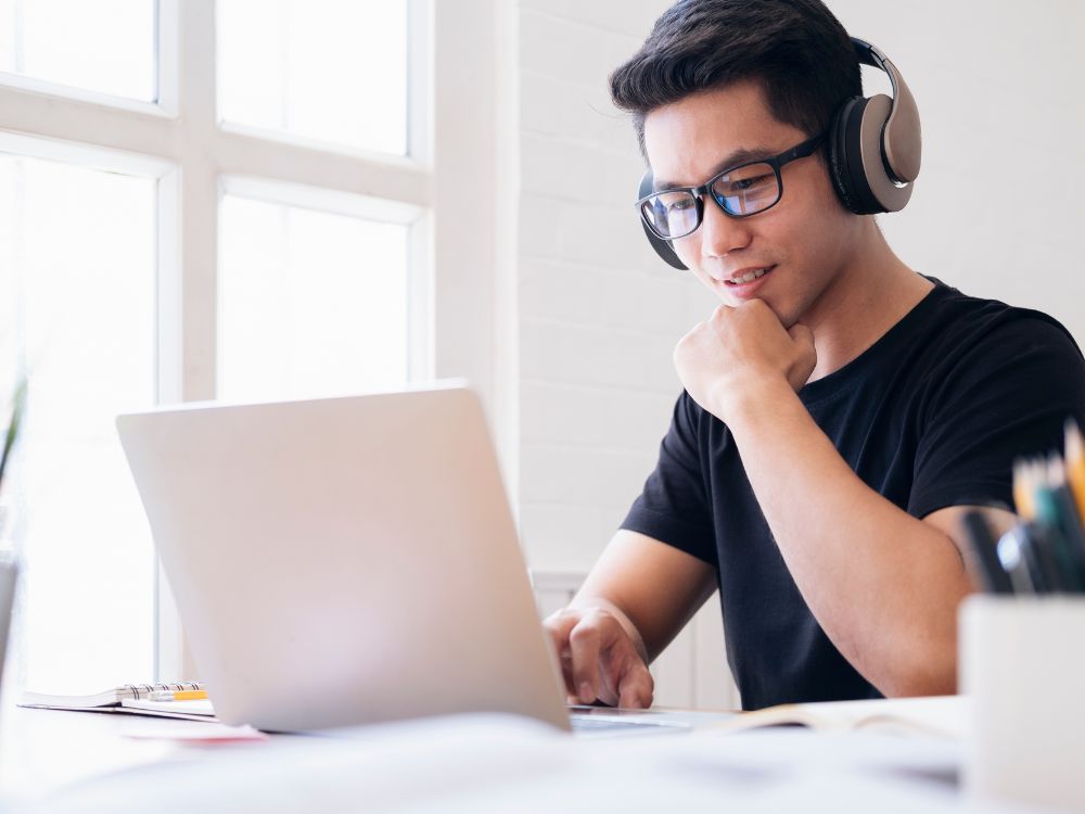 Estudante em chamada online se informa sobre como evitar a baixa previsibilidade de matrículas usando tecnologia educacional.