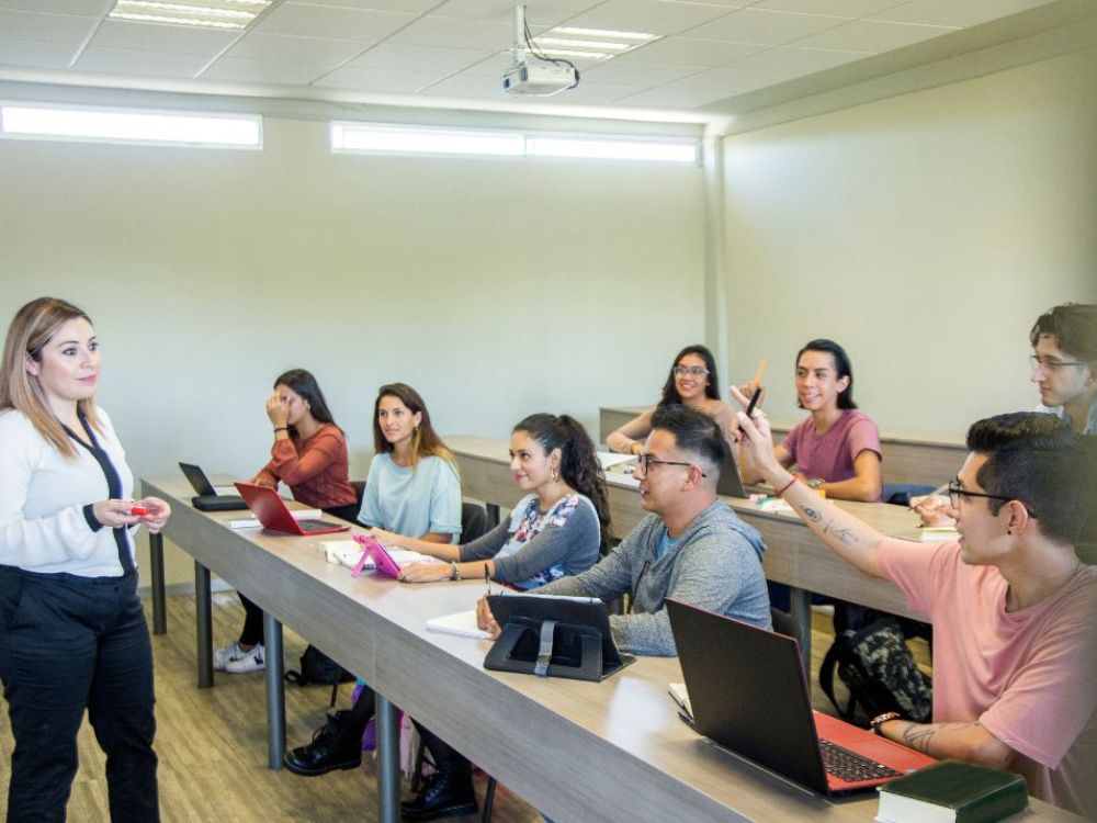 Alunos em sala de aula com notebooks e tablets, ilustrando o que é educação digital e como a tecnologia transforma o processo de ensino-aprendizagem.