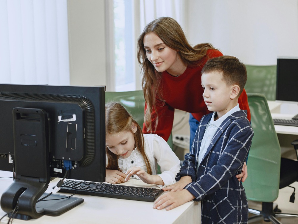 Crianças aprendendo no computador com suporte do Software Educacional.