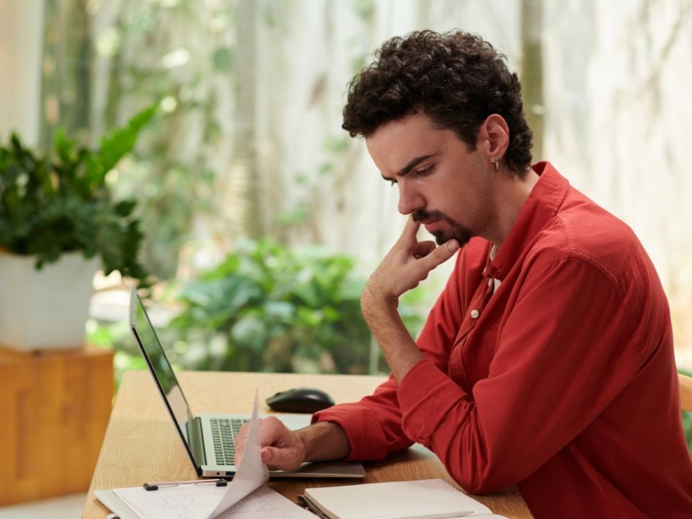Gestor escolar analisa relatórios no computador, utilizando dados e ferramentas digitais para monitorar indicadores educacionais da instituição.