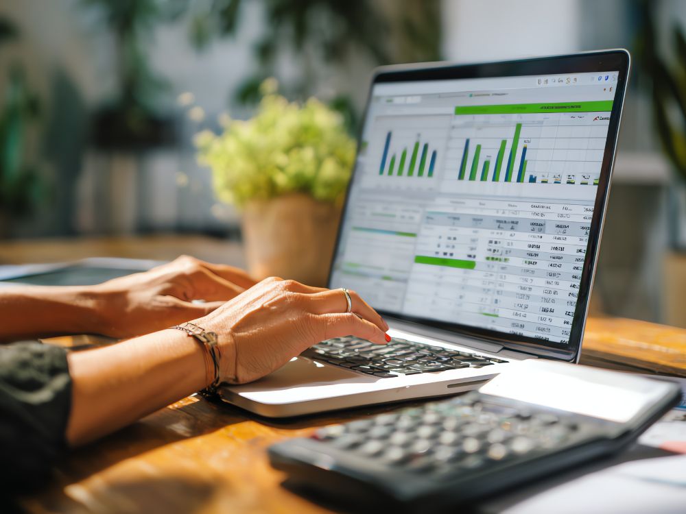 Profissional analisando gráficos financeiros no notebook, representando o uso de tecnologia na gestão financeira escolar eficiente.
