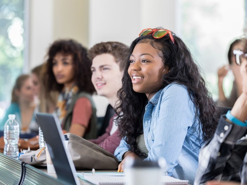 Estudantes atentos em sala de aula, demonstrando engajamento e participação como parte da boa experiência do aluno na educação.