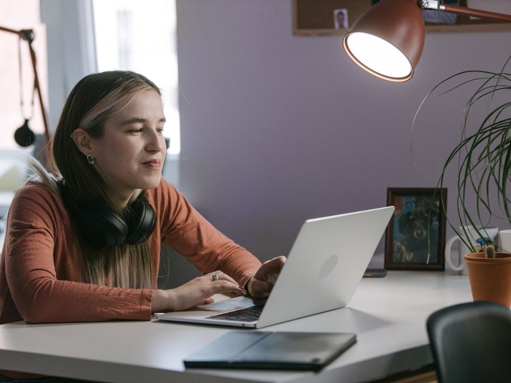 Estudante estudando em notebook em ambiente doméstico, ilustrando o uso de ferramentas digitais na educação no ensino remoto.