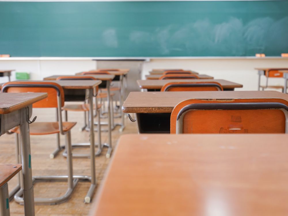 Sala de aula vazia com carteiras organizadas, imagem que simboliza ausência de alunos e reforça os indicadores de evasão escolar.