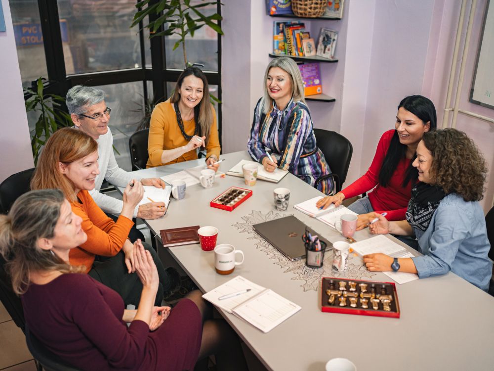 Reunião de equipe mostrando a importância da comunicação na escola entre professores, coordenação e colaboradores para melhorar o ambiente educacional.
