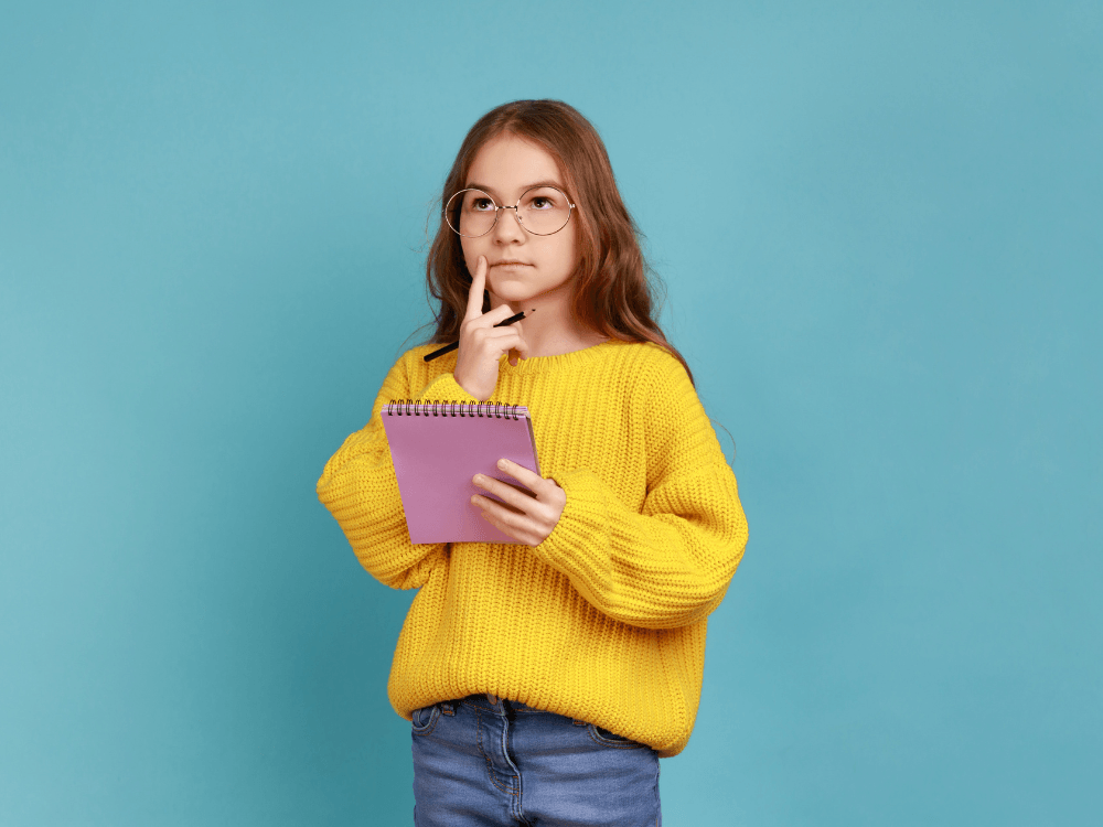 Estudante segura um bloco de anotações enquanto planeja atividades, representando a importância da organização escolar.